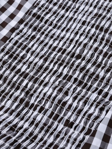 Detailed macro view of black and white gingham fabric with elastic smocking textures