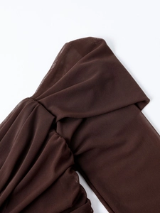 Detailed close-up of brown sheer mesh fabric with elegant pleated and layered design textures