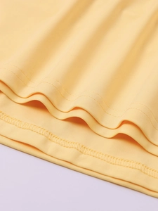 Détail du gros plan sur la double piqûre et les coutures surjetées d'un tissu jaune clair