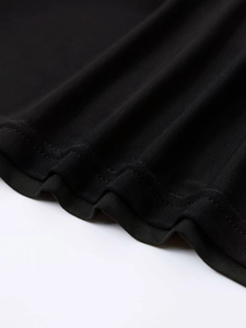 Detail of black mesh fabric showing fine texture and professional hemming on the dress