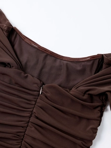Detail shot of a sheer brown mesh dress with fine ruching and a hidden zipper back