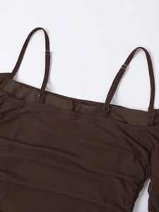 Detail of adjustable thin straps with silver buckles on dark brown mesh dress fabric