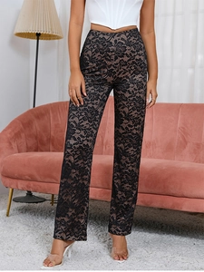 Détail du pantalon en dentelle florale noire à taille haute avec doublure nude lisse