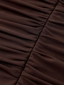 Detail of sheer brown mesh fabric with fine shirring and elastic texture on a slim dress