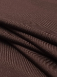Close-up of deep brown ribbed knit fabric showing detailed vertical texture and soft folds