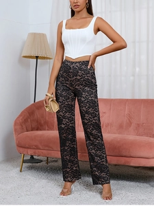 Détail du pantalon en dentelle florale noire à taille haute avec une doublure beige élégante
