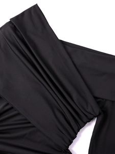 Detail of elegant black milk silk fabric with ruched texture and gathered design on dress