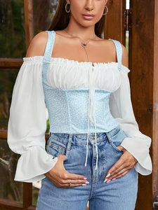 Detailed view of floral corset top with white lantern sleeves and lace-up front design