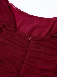 Detailed close-up of wine red mesh dress featuring a hidden zipper and pleated texture