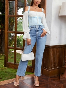 Detail of floral chiffon corset top with white puff sleeves and light blue jeans outfit