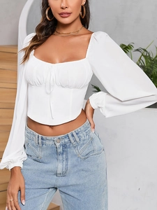 Detail of white long sleeve crop top with sweetheart neckline and ruched drawstring texture