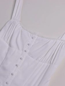Detailed view of white dress with lace trim, bust ruching, and fabric-covered buttons