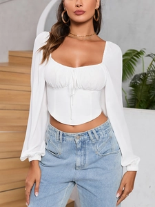 Detail of white square neck crop top with lace-up front and curved corset style hem