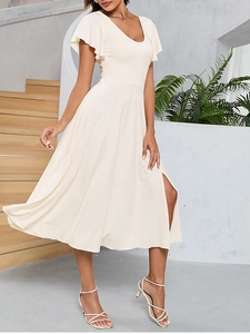 Détail des manches à volants et du col en V sur une robe beige avec fente latérale