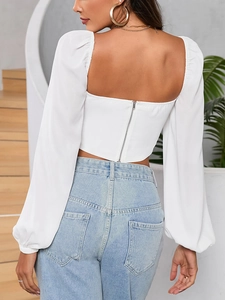 Back view of a white square neck crop top with lantern sleeves and a metal zipper