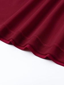 Detail of burgundy mesh dress hem showcasing high-quality double-needle stitching finish