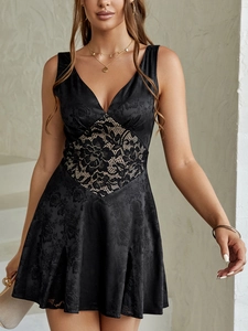 Detail of black satin A-line dress with floral jacquard texture and lace patchwork insert
