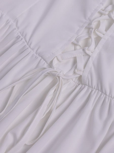 Detailed macro view of white lace trim dress with criss-cross drawstring and pleated fabric