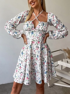 Detailansicht des Blumenmusters und des überkreuzten Neckholders am kurzen Minikleid