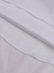 Close-up detail of white ribbed knit fabric texture and smooth textile stitching