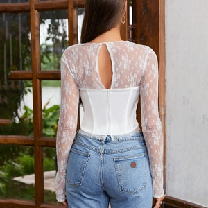 Top a corsetto in pizzo bianco con maniche lunghe e schiena scoperta con jeans blu