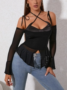 Detail of sheer mesh patchwork long sleeve top with halter neck and flared cuffs
