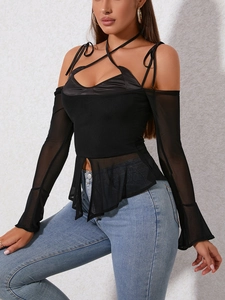 Detail of sheer mesh flare sleeves and halter cutout design on a black mesh patchwork top