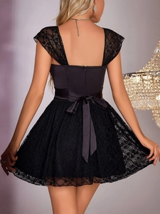 Detailed back view of black lace dress with elegant satin bow and invisible zipper