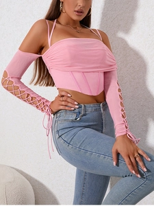 Detail of pink corset top with boning structure and lace-up hollow out sleeves