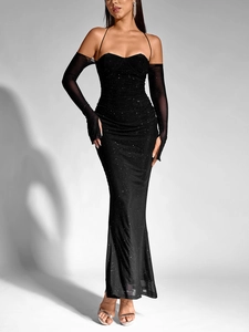 Dettaglio dell'abito nero con paillettes, maniche in tulle e silhouette a sirena elegante