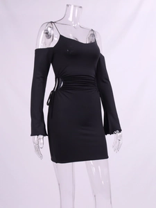 Detail of black cut-out dress featuring side ruching and elegant long sleeve construction