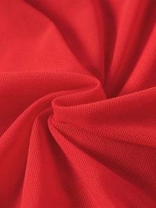 Gros plan sur le tissu en résille rouge vif avec texture respirante et plis souples