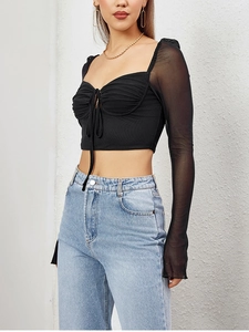 Detail of sweetheart neckline and adjustable drawstring on black mesh crop top