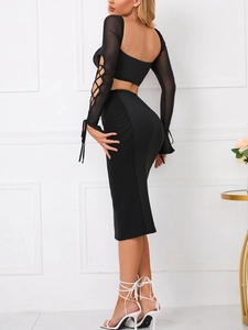 Detail of sexy black long sleeve crop top with mesh lace-up sleeves and matching midi skirt