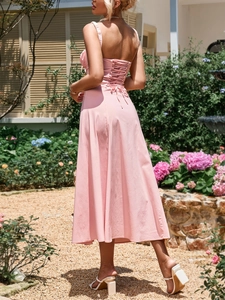 Detail of light pink midi dress featuring a criss-cross lace-up back and tie closure