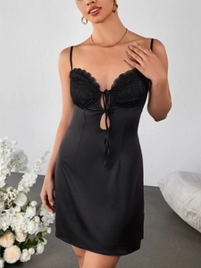 Détail de la robe nuisette en satin noir avec dentelle et découpes frontales évidées