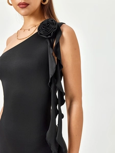 Detail of elegant black one-shoulder dress with 3D rose flower and ruffled drapery