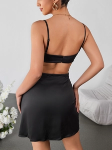 Détail d'une mini robe en satin noir montrant le dos nu et les fines bretelles spaghetti