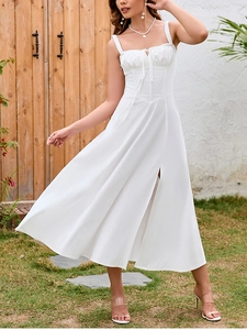 Close-up of white summer dress featuring backless tie-up details and high slit skirt