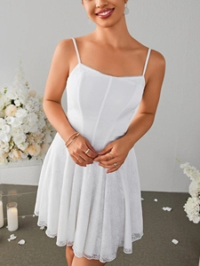 Close-up of white mini dress featuring corset seams and pleated lace floral hemline