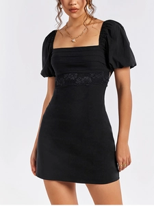 Close-up of black square neck dress featuring puff sleeves and floral lace waist detailing