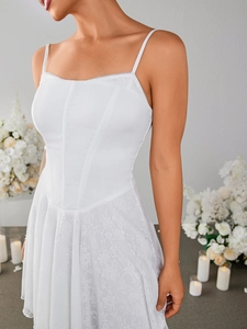 Close-up detail of white lace corset dress with delicate floral texture and strap details