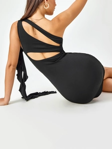 Detail of black one-shoulder dress showing cut-out back and elegant ruffle texture