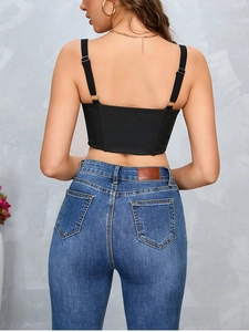Back view of a black mesh corset top with adjustable straps and denim jeans styling