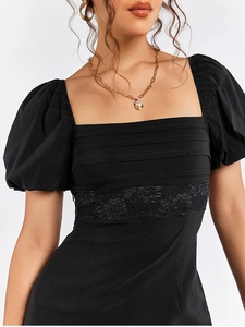 Detail of square neckline, puff sleeves, and lace trim on a black mini dress