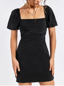 Close-up of black dress with square neck, puff sleeves, and intricate floral lace waist
