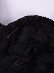 Close-up of black mesh fabric detail with delicate pleated edges and semi-transparent texture
