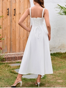 Detailed corset-style lace-up back of a white midi dress with slim straps and A-line silhouette