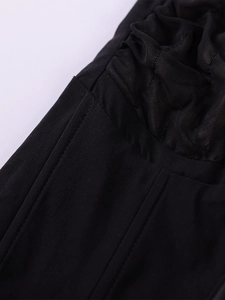 Detail of mesh corset top featuring vertical boning and structured stitching in black