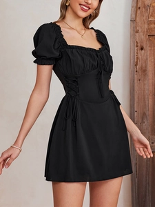 Detail of black mini dress with puff sleeves, square neckline, and side waist ties